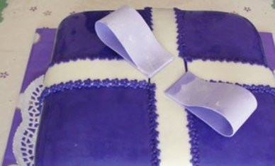 1. Этап. Торт Подарок: А теперь начинаем формировать бант. Смазываем петельки водой и прикрепляем к торту в центре.