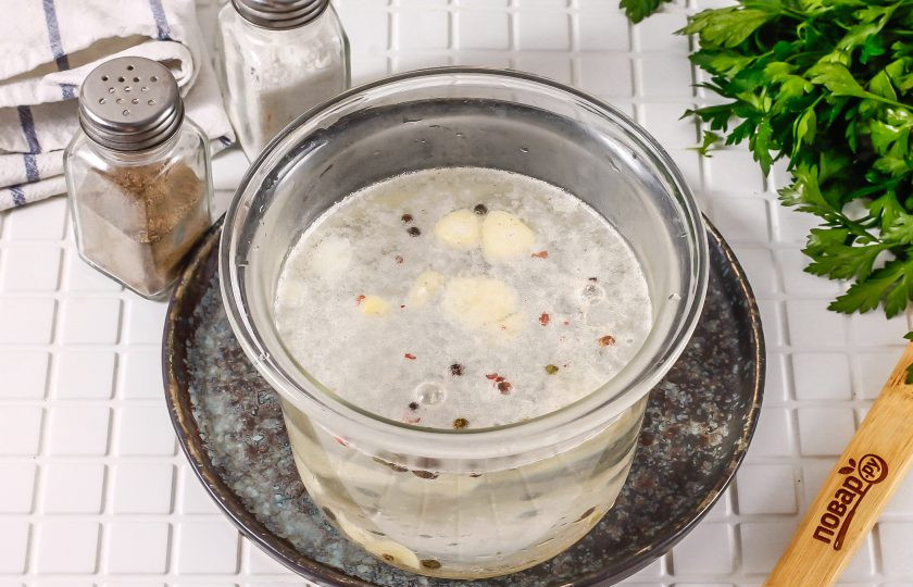 1. Этап. Пузанина в рассоле с чесноком: Вскипятите воду и влейте ее в емкость. Тщательно перемешайте и остудите в течение 1-2 часов до теплого состояния, примерно до 20-25 градусов.