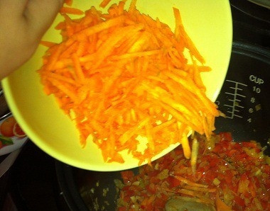 1. Этап. Баклажанная икра в мультиварке: Морковь вымойте и очистите от кожуры, поскоблив острым ножом. Натрите корнеплод на крупной терке или нарежьте соломкой. Добавьте морковь к остальным овощам, перемешайте ингредиенты деревянной или пластиковой лопаткой.