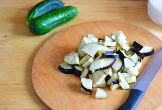 1. Этап. Салат на зиму из баклажанов: 7. Вымойте, обсушите и удалите хвостики у баклажан. Нарежьте их небольшими кубиками.