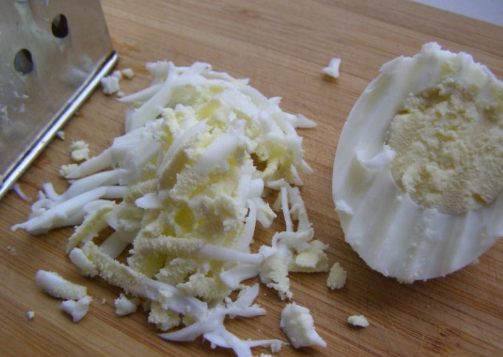 1. Этап. Салат из кукурузы и яиц: Яйца отварите в кипящей воде до готовности, вкрутую. Остудите, очистите и натрите на терке.