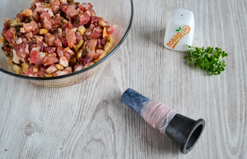 1. Этап. Домашняя колбаса с грибами: Свиную кишку хорошо промойте снаружи и внутри. Наденьте ее на специальную насадку для мясорубки, а затем установите на саму мясорубку. Наполните кишку подготовленной начинкой.