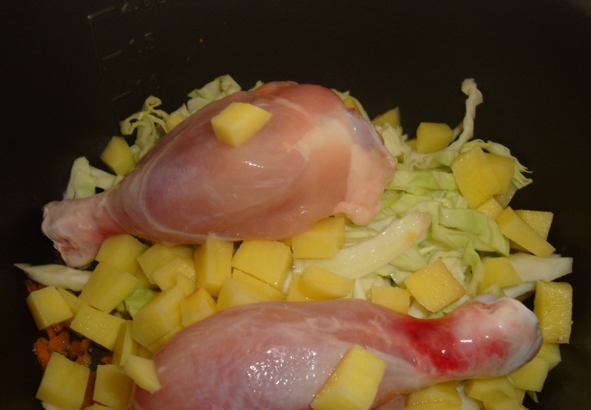 1. Этап. Кислые щи с курицей: 2. Теперь выкладываем картошку кубиками, капусту и куриные голяшки. Добавим специи и аккуратно перемешаем. По желанию можно добавить немного масла - чтобы щи получились сытнее.