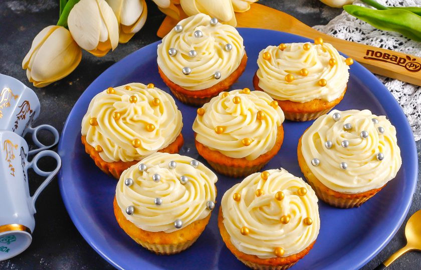 1. Этап. Капкейки с кремом Пломбир: По желанию вы можете вырезать серединки кексов, чтобы в них стало больше крема. Поместите крем в кулинарный шприц и отсадите на капкейки кремовые шапочки. Украсьте их посыпкой или кусочками фруктов, ягодами.