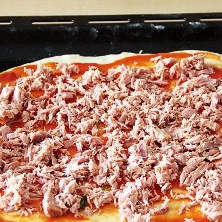 1. Этап. Пицца с тунцом: Тунец разомните вилкой и затем равномерно разложите на основу. Можно добавить кольца красного лука.