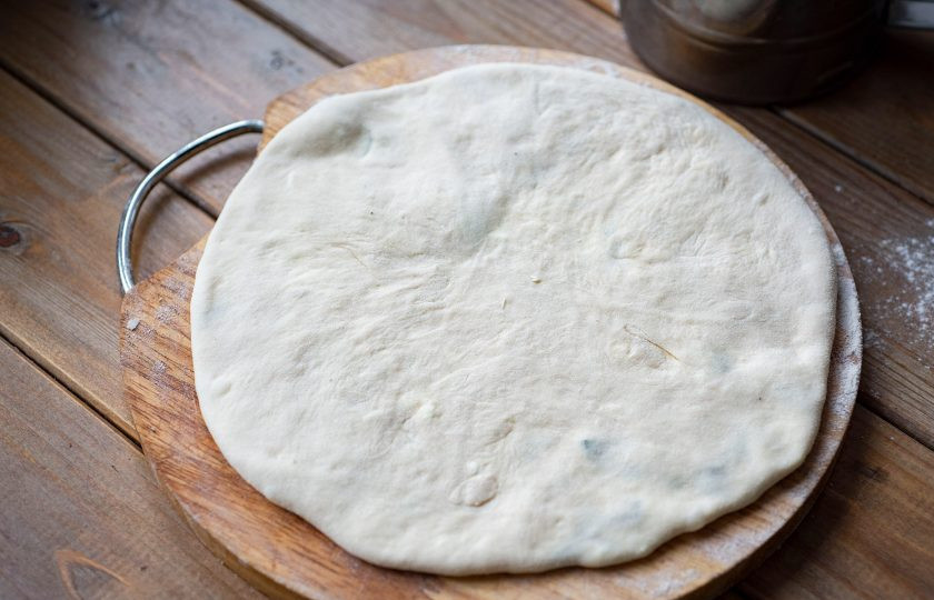 1. Этап. Хычины с творогом: Раскатайте тесто с начинкой в тонкую лепешку.