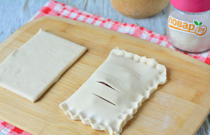 1. Этап. Слойки из слоеного теста с клюквой: Защипните слойки со всех сторон, завернув свободный край теста наверх.