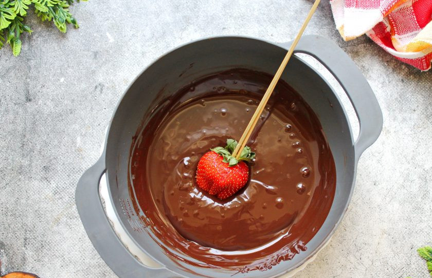 1. Этап. Летний торт: Теперь нужно работать очень быстро, так как шоколад быстро застывает на клубнике, а так же начинает остывать. Окуните каждую ягоду клубнику в шоколад, отряхните лишний шоколад.