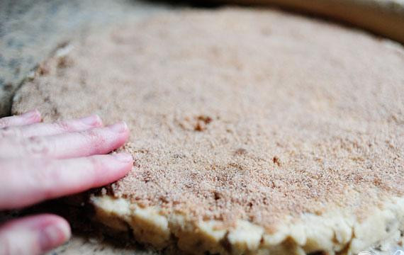 1. Этап. Коричное печенье: 5. Выложить тесто на рабочую поверхность. Смесь будет очень рыхлой и может разваливаться. Аккуратно раскатать тесто в большой круг или большой прямоугольник. Отпавшие кусочки теста смешать с корицей и посыпать массой поверхность раскатанного теста, слегка прижимая их.