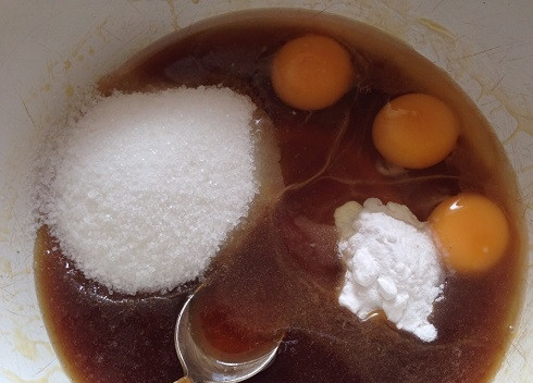 1. Этап. Детский торт своими руками: Мед у меня гречишный, поэтому темный. Добавляем к медово-масляной смеси яйца, сахар и соду. Перемешиваем.