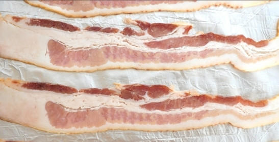 1. Этап. Мясные рулетики в фольге: 1. Рецепт приготовления мясных рулетиков в фольге начинается с маринования мяса. Курицу (можно использовать не только филе, но и мясо с голени, например) и индейку вымыть, просушить бумажным полотенцем и нарезать тонкими полосочками. Соединить в небольшой мисочке, посолить и поперчить по вкусу. Добавить щепотку розмарина и оставить на 15-20 минут. При желании можно добавить немного острого соуса или горчицы. Тем временем можно заняться подготовкой бекона. На лист фольги выложить полосочки бекона на небольшом расстоянии.