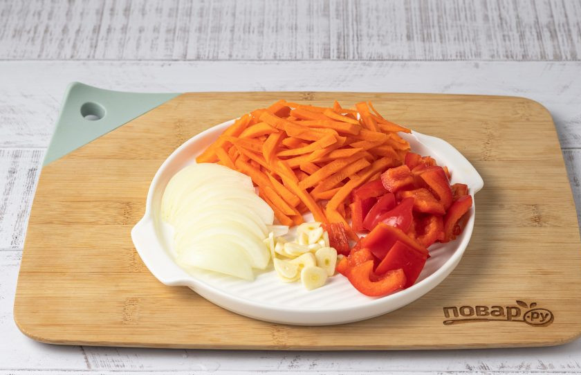 1. Этап. Маринованные шампиньоны с овощами: Репчатый лук нарежьте полукольцами, морковь брусочками, а болгарский перец кубиками. Чеснок очистите от шелухи и порежьте пластинами.