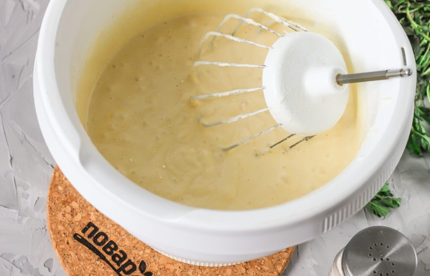 1. Этап. Бисквит на горячем молоке: Только после добавления муки влейте в тесто горячее молоко с маслом и сразу же начните перемешивать на малых оборотах, вмешивая жидкость в тесто. Разогрейте духовку до 180 градусов.