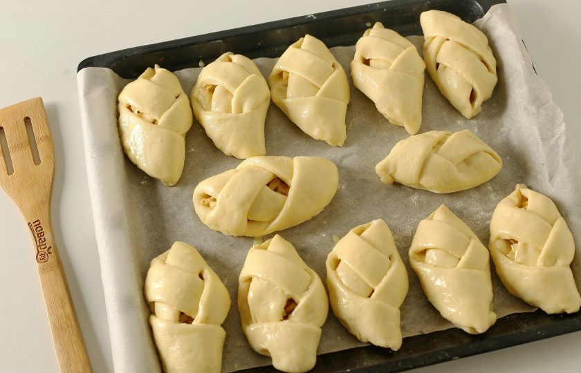 1. Этап. Булочки с курицей и сыром: Переложите заготовки на противень, накройте полотенцем и оставьте для расстойки на 20 минут. Затем смажьте желтком и выпекайте в духовке при температуре 200 градусов около 20 минут.