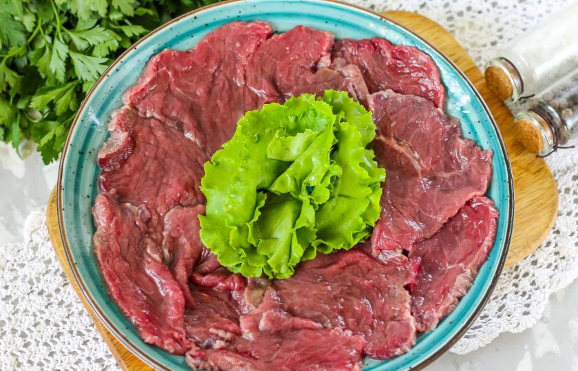 1. Этап. Карпаччо из говядины: Спустя указанное время промойте листья салата, из мяса на тарелке сформируйте круг и в середину выложите промытую зелень.