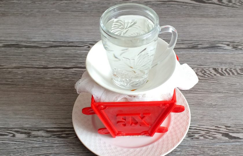 1. Этап. Пасха с вареной сгущенкой: Прикройте верх пасочницы свисающими концами марли, сверху поставьте груз и уберите в холодильник на 10-12 часов.