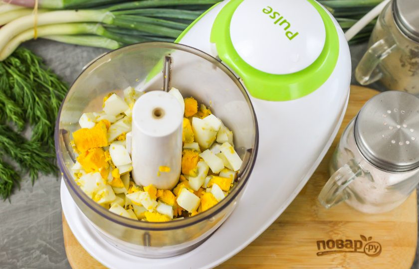 1. Этап. Паштет из красной рыбы: Куриные яйца очистите от скорлупы, промойте в воде и нарежьте кубиками. Высыпьте нарезку в чашу блендера или в глубокую емкость, если будете использовать погружной блендер.