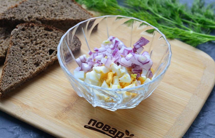 1. Этап. Бутерброды с молоками сельди: Нарежьте лук кубиками и всыпьте к яйцам.