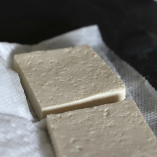 1. Этап. Припущенный тофу: Каждый ломтик тофу необходимо обсушить на бумажном полотенце, чтобы впиталась лишняя влага.