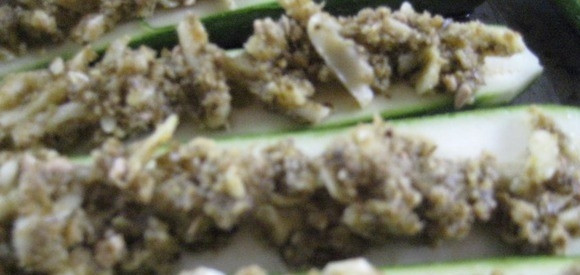 1. Этап. Печеные кабачки в духовке: Выложите смесь ложкой на половинки кабачков. Хорошенько разровняйте по всей поверхности. Можете посыпать любимыми специями или травами.