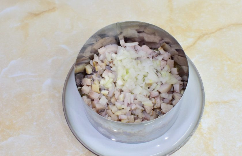 1. Этап. Салат Сельдь под шубой: Затем выложите слой нарезанной сельди и мелко нарезанного лука. Промажьте майонезом.