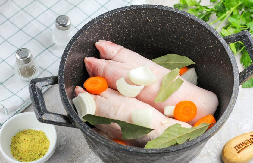 1. Этап. Желе из мясного бульона: Выложите мясные части в казан или кастрюлю и добавьте нарезанные на части овощи, они придадут бульону яркий вкус и аромат. Всыпьте лавровые листья.