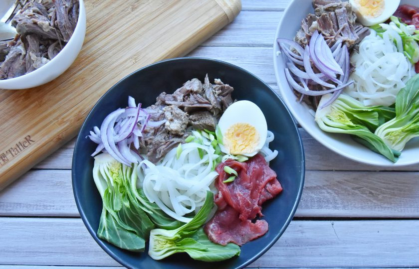 1. Этап. Фо бо (классический рецепт): В глубокую тарелку выложите подготовленные составляющие супа: рисовую лапшу, отварное мясо, зеленый лук, перья красного лука, половинки яйца, пак-чой, ломтики сырой говядины, колечки острого перца чили.