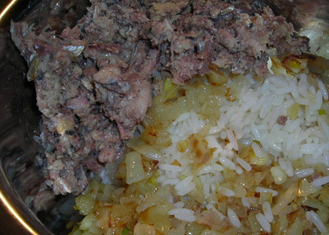 1. Этап. Пирог из сайры с рисом: Лук режем на кубики и обжариваем на сковороде до золотистости. Отварной рис смешиваем с обжаренным луком. Консервы разминаем вилкой. Смешиваем их с рисом и луком. Можно немного досолить и добавить специй.