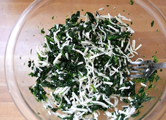 1. Этап. Пицца со шпинатом, луком и сыром: 3. Моцареллу натрите на мелкой терке и выложите к шпинату, перемешайте все хорошенько.