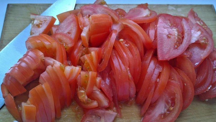 1. Этап. Салат с кальмарами и солеными огурцами: Помидоры нарежьте тонкими ломтиками. Жидкость от них слейте.