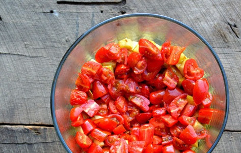 1. Этап. Слоеный салат Праздничный: 3. Помидоры нарежьте наполовину, слегка прогрейте в той же сковороде, где жарили овощи, добавив масла. Выложите третьим слоем.