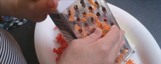 1. Этап. Плов из окорочков: 4. Натираем морковь и отправляем туда же. Перемешиваем мясо с овощами и жарим до золотистого цвета.