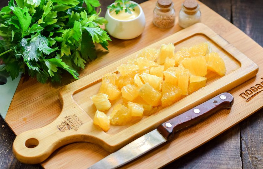 1. Этап. Салат с апельсином и чесноком: Апельсин очистите, удалите белые прожилки и семена. Нарежьте апельсин небольшими кусочками.