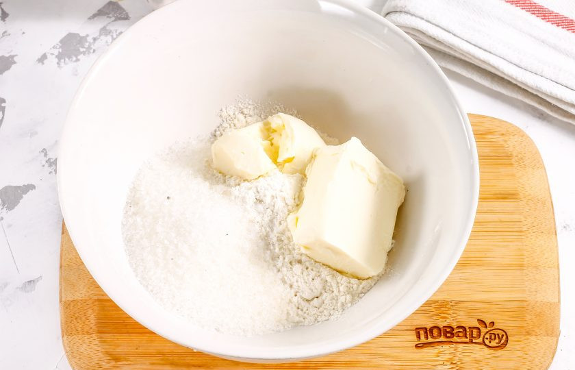 1. Этап. Сметанник из песочного теста: Выложите в глубокую емкость сливочное масло комнатной температуры, всыпьте пшеничную муку, половину сахарного песка и соль. Тщательно разотрите.