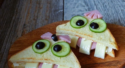 1. Этап. Сэндвичи Зубастики: Оставшийся хлеб смазать творожной массой, накрыть. Из ветчины сделать чубчик и бантик. На капельки соуса 