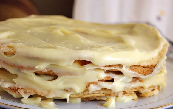 1. Этап. Торт из готового слоеного теста: 6. Каждый корж щедро смажьте кремом. Остатки крема распределите по бокам и сверху. Измельчите обрезки коржей, присыпьте получившейся крошкой тортик.