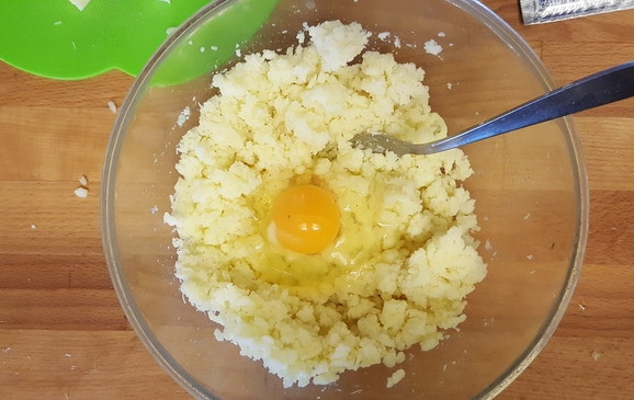 1. Этап. Картофельные бомбочки в духовке: 1. Картофель почистите, промойте и отварите до готовности. Разомните картофель, добавьте яйцо.