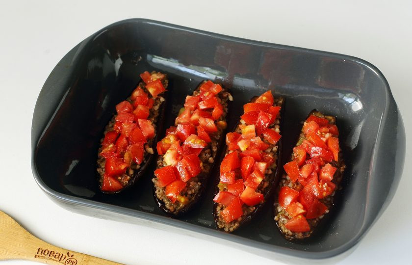 1. Этап. Баклажаны фаршированные гречкой: Сверху выложите нарезанные кубиками помидоры.