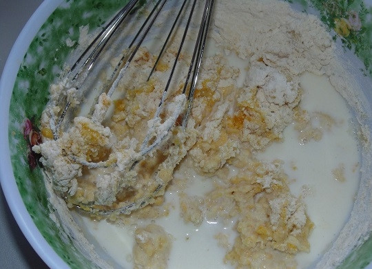 1. Этап. Оладьи из кукурузной муки: 2. Влейте молоко и растопленное сливочное масло. Взбейте тесто, чтобы не было комочков. Можно оставить на 5-10 минут, а после еще раз взбить.