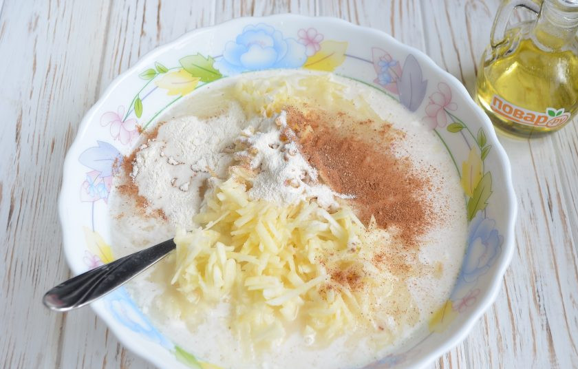 1. Этап. Манник на сыворотке: 3. Яблоки вымойте и снимите кожуру, натрите на крупной терке. Добавьте в манник. Туда же всыпьте корицу, разрыхлитель и хорошенько все перемешайте.