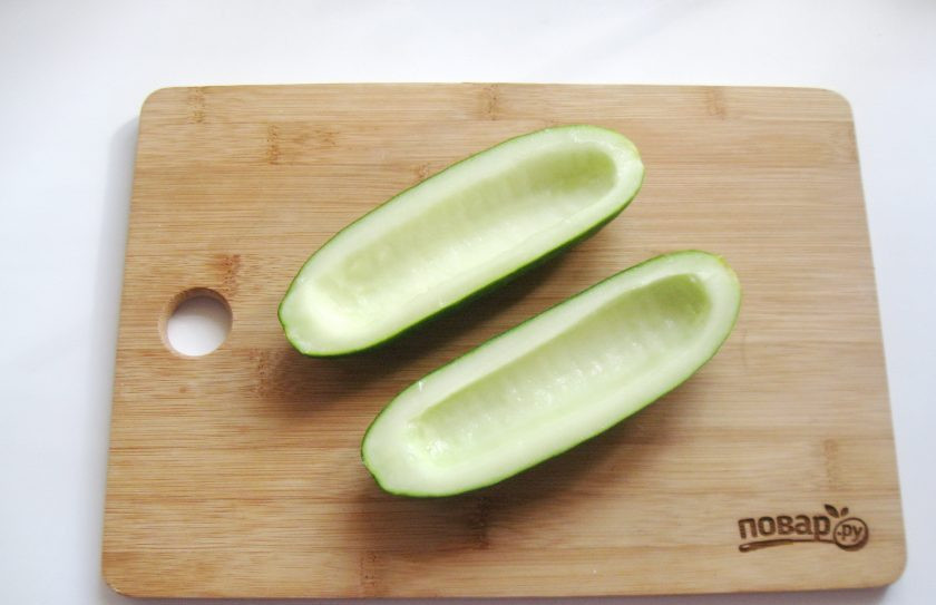 1. Этап. Жареные огурцы с грибами: Огурец помойте, высушите и разрежьте на две части вдоль. Удалите семечки чайной ложкой.
