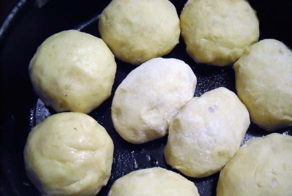 1. Этап. Картофельные шарики с начинкой: В глубокую жаропрочную сковороду влейте масло. Выложите туда шарики. Сделайте заливку, смешав томатный сок со сметаной и солью.