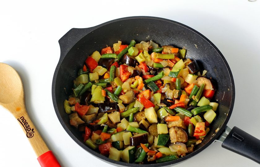 1. Этап. Гювеч с мясом: Лук, морковь, кабачок, баклажан, перец и фасоль обжарьте до мягкости с добавлением соли. Добавьте измельченный чеснок, помидоры дольками и готовьте все вместе еще пару минут. Если помидоры кисловатые, можно добавить немного сахара.