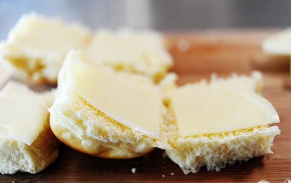 1. Этап. Мини-сэндвичи с фрикадельками: 4. Когда фрикадельки готовы, разрезать каждую булочку для сэндвичей пополам. Выложить кусочек сыра Проволоне сверху и снизу каждой половинки булочки.