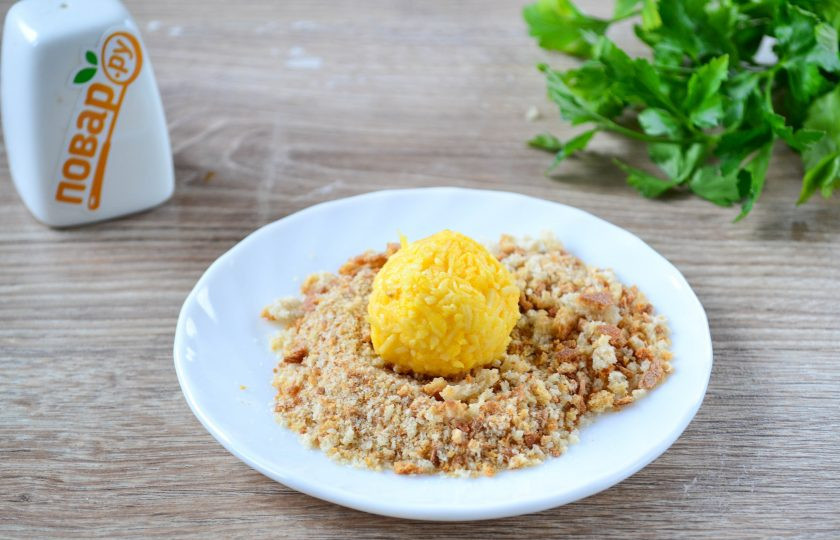 1. Этап. Сырные шарики во фритюре: Из полученной сырной массы сформируйте шарики и обваляйте их в панировочных сухарях.