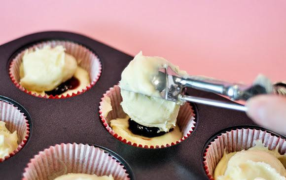 1. Этап. Капкейки с малиновым джемом и лимонной глазурью: 3. Выложить 1 чайную ложку малинового джема поверх теста, а сверху еще 1 столовую ложку теста.