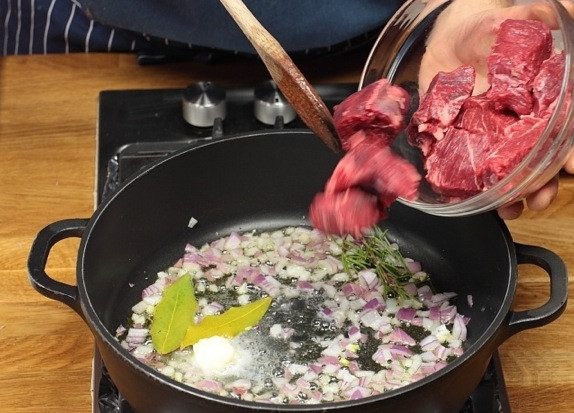 1. Этап. Говядина с картошкой: В сковороде разогреть оливковое масло, растопить в нем сливочное. Обжарить лук и лавровый лист в течение пары минут, после чего добавить говядину и жарить на среднем огне, помешивая, пока мясо со всех сторон не поменяет цвет.