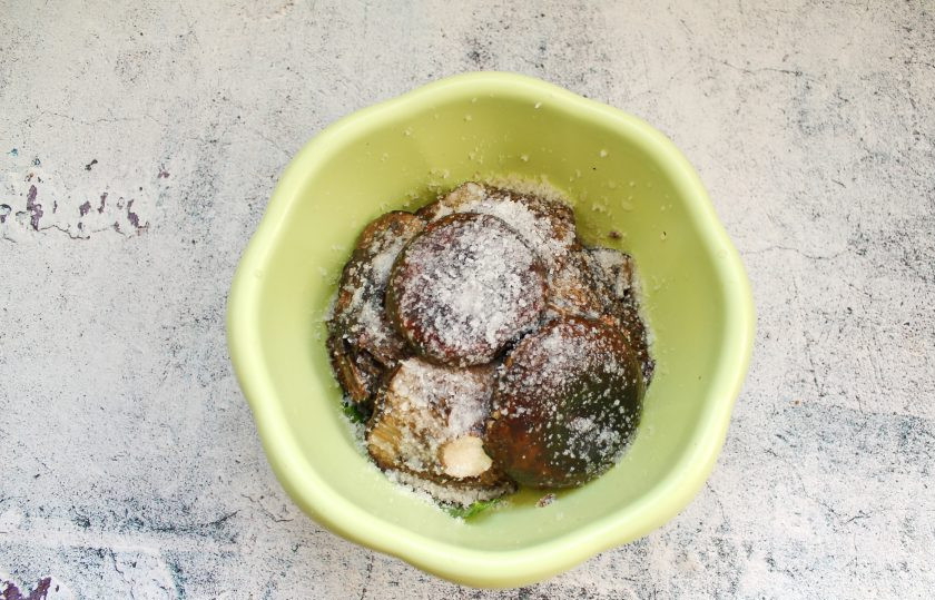 1. Этап. Черные грузди на зиму: Укладывайте подготовленные черные грузди слоями, пересыпая каждый слой солью. Через два слоя грибов добавляйте немного зелени и нарезанный чеснок.