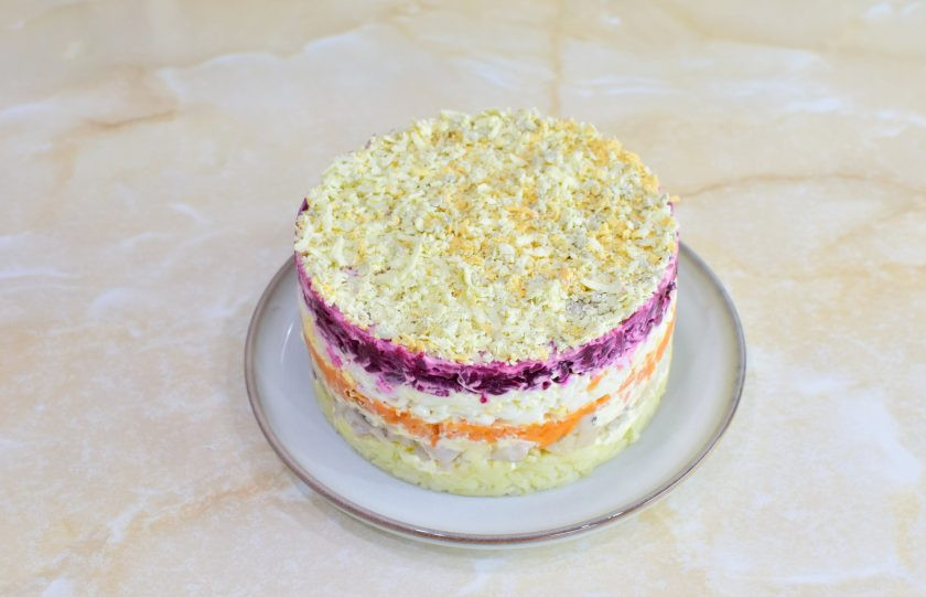 1. Этап. Салат Сельдь под шубой: Сверху потрите на мелкой терке отложенные желтки и снимите с салата кольцо.