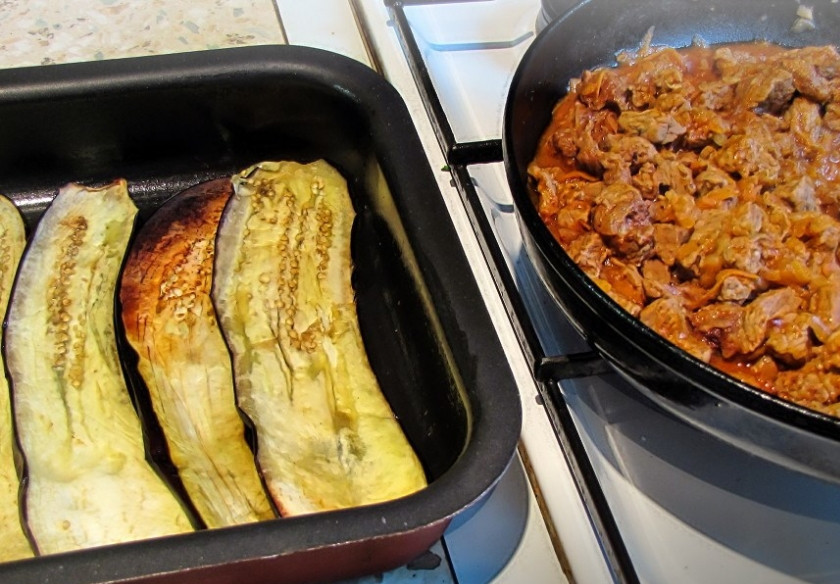 1. Этап. Мусака с бараниной: Баклажаны моем и режем на тонкие ломтики вдоль. Посыпаем ломтики солью и оставляем минут на 15. Затем смываем соль и удаляем при помощи бумажного полотенца лишнюю влагу. Эта операция стандартна при приготовлении баклажанов: так из них выводится излишняя горечь. Далее баклажаны нужно обжарить или запечь. Мы предпочитаем второй вариант: слегка смазав ломтики маслом (оливковым), выкладываем их на противень и помещаем в разогретую духовку, где держим до «коричневатого состояния».